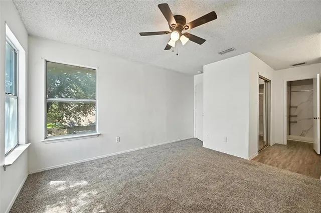 an empty room with fan and windows