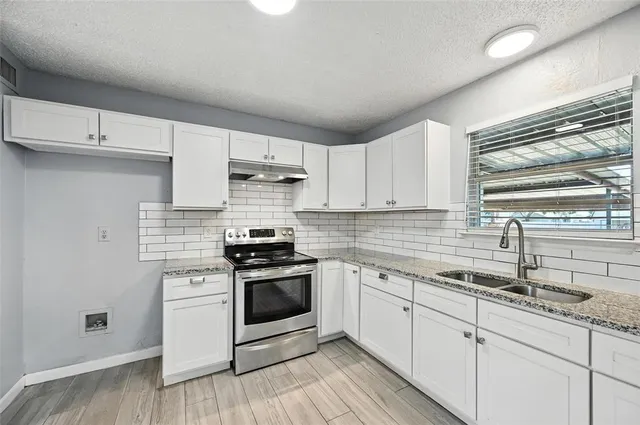 a kitchen with stainless steel appliances granite countertop a sink and stove top oven