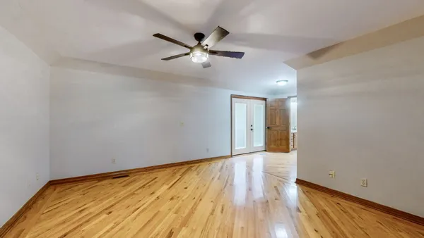 an empty room with a window and a ceiling fan