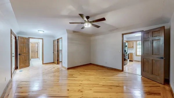a view of an empty room with wooden floor