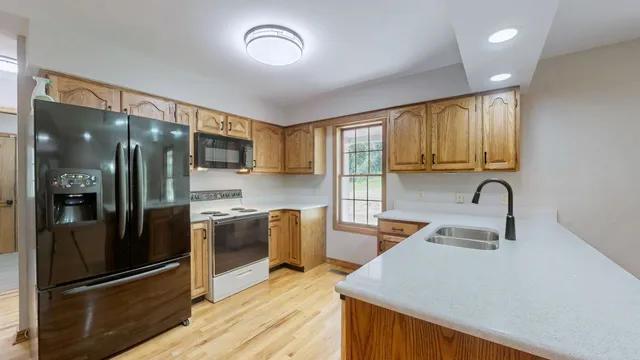 a kitchen with stainless steel appliances granite countertop a refrigerator and a sink