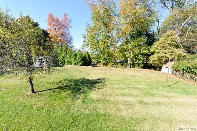 a view of yard with tree and wooden fence