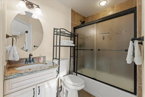 a bathroom with a granite countertop sink toilet and shower