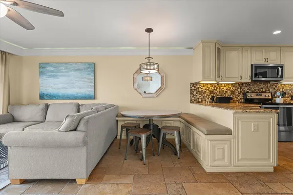 a living room with furniture a flat screen tv and kitchen view