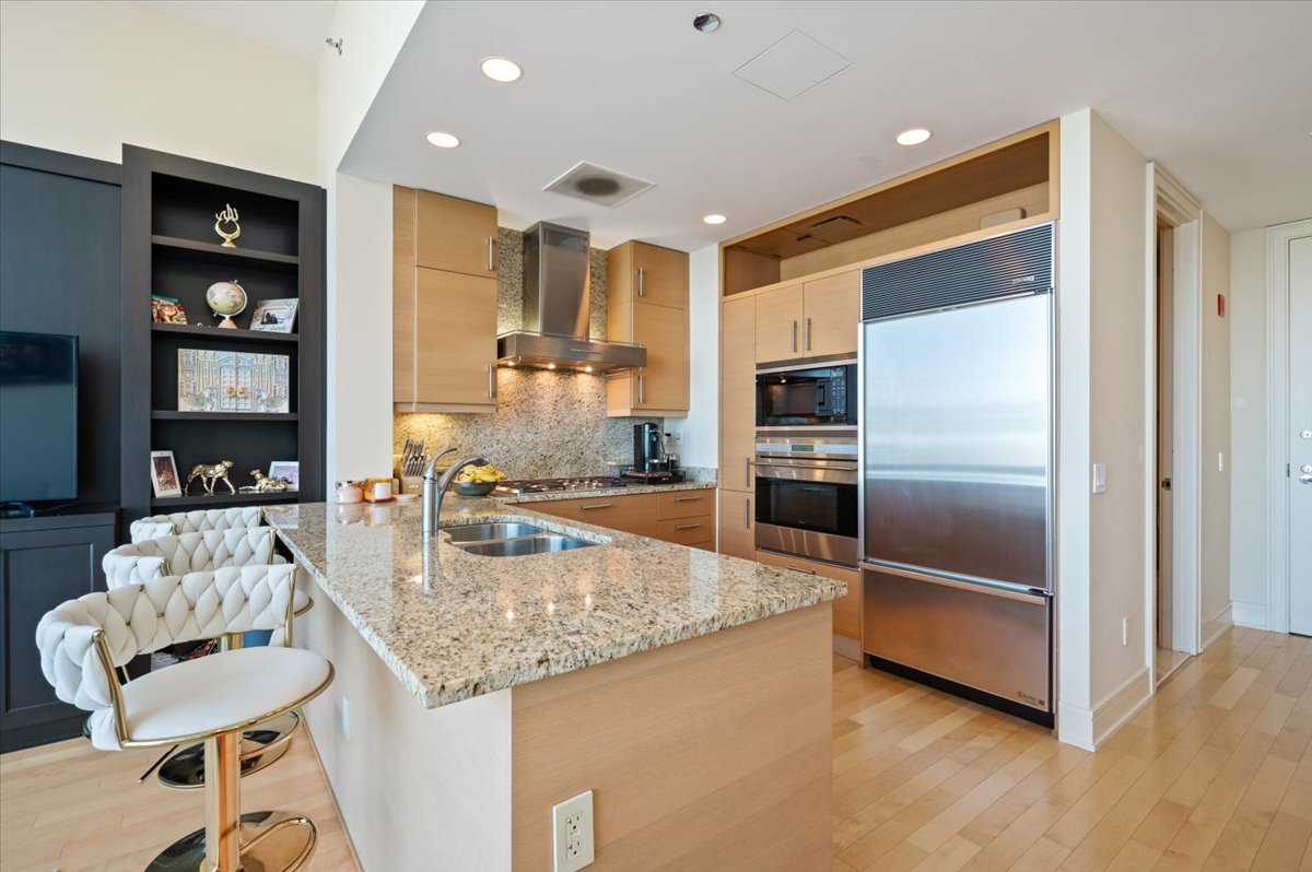 401 North Wabash Avenue, Unit 71C Chicago, IL 60611 - Photo 4 of 38 a kitchen with stainless steel appliances granite countertop a refrigerator and a stove top oven