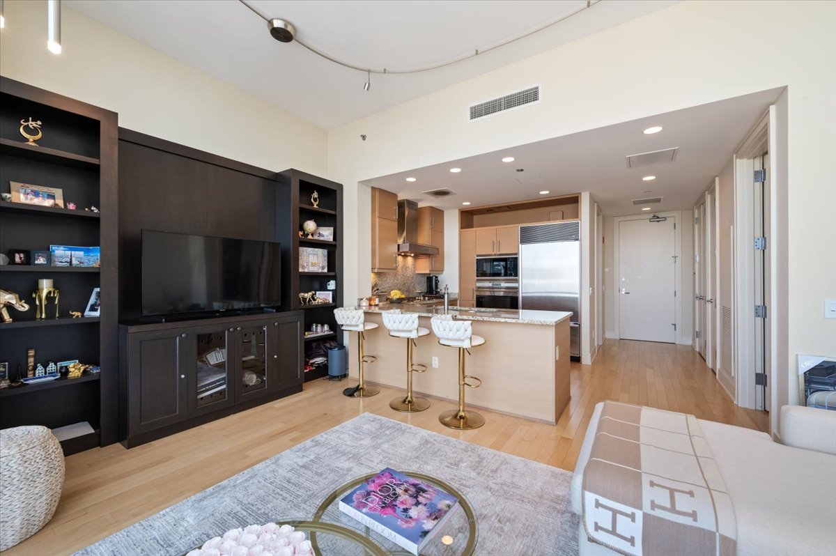 401 North Wabash Avenue, Unit 71C Chicago, IL 60611 - Photo 6 of 38 a living room with furniture a flat screen tv and kitchen view