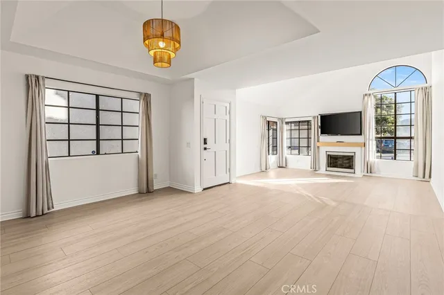 an empty room with a fireplace and wooden floor