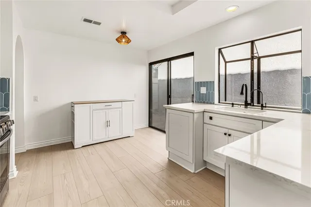 a view of a kitchen with a sink and dishwasher with wooden floor