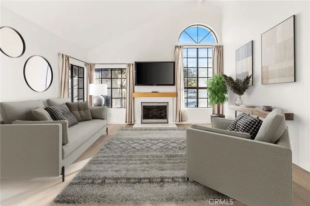 a living room with furniture a flat screen tv and a fireplace