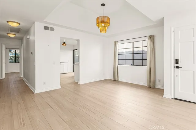 a view of empty room with wooden floor and window