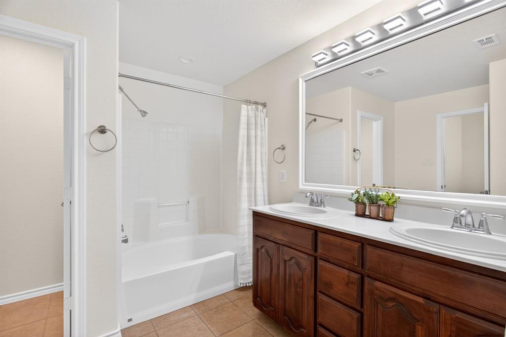 5069 Britton Ridge Lane Fort Worth, TX 76179 - Photo 18 of 32 Ensuite bathroom features big vanity with two sinks, tub-shower combo, and a separate toilet.