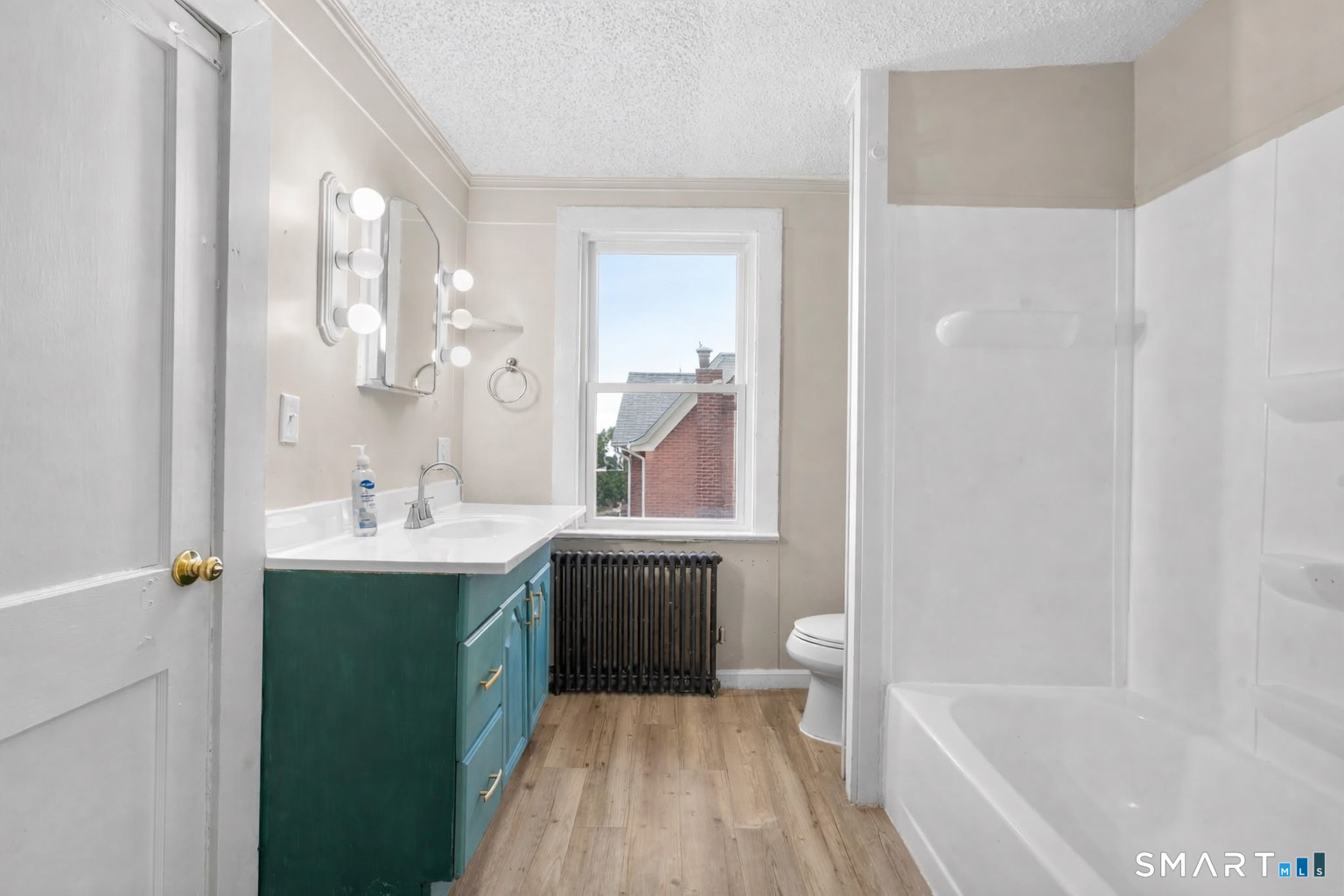 301 Queen Street Bristol, CT 06010 - Photo 12 of 26 a bathroom with a tub sink toilet and a mirror