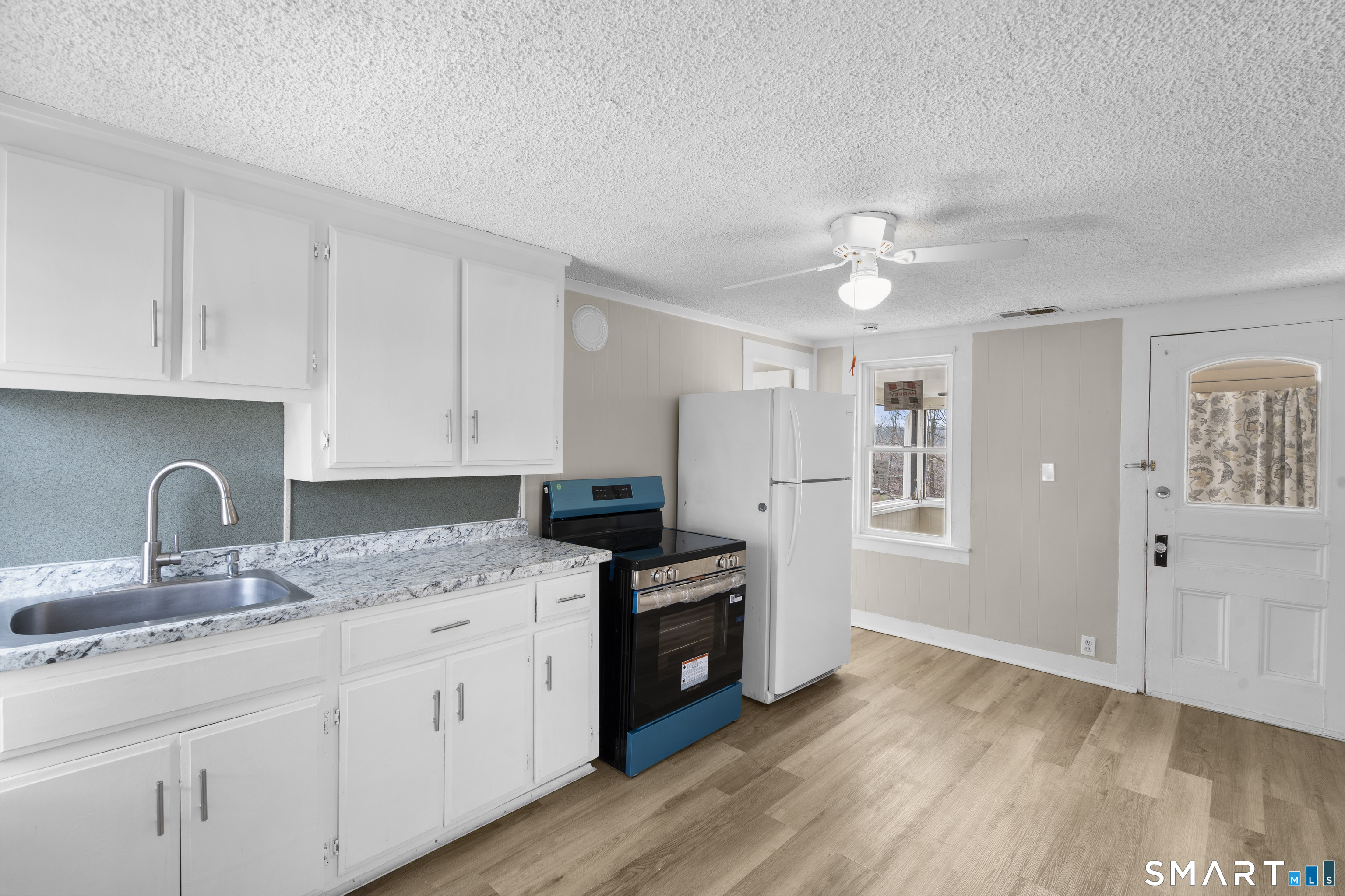 301 Queen Street Bristol, CT 06010 - Photo 21 of 26 a kitchen with granite countertop a sink cabinets stainless steel appliances and a window