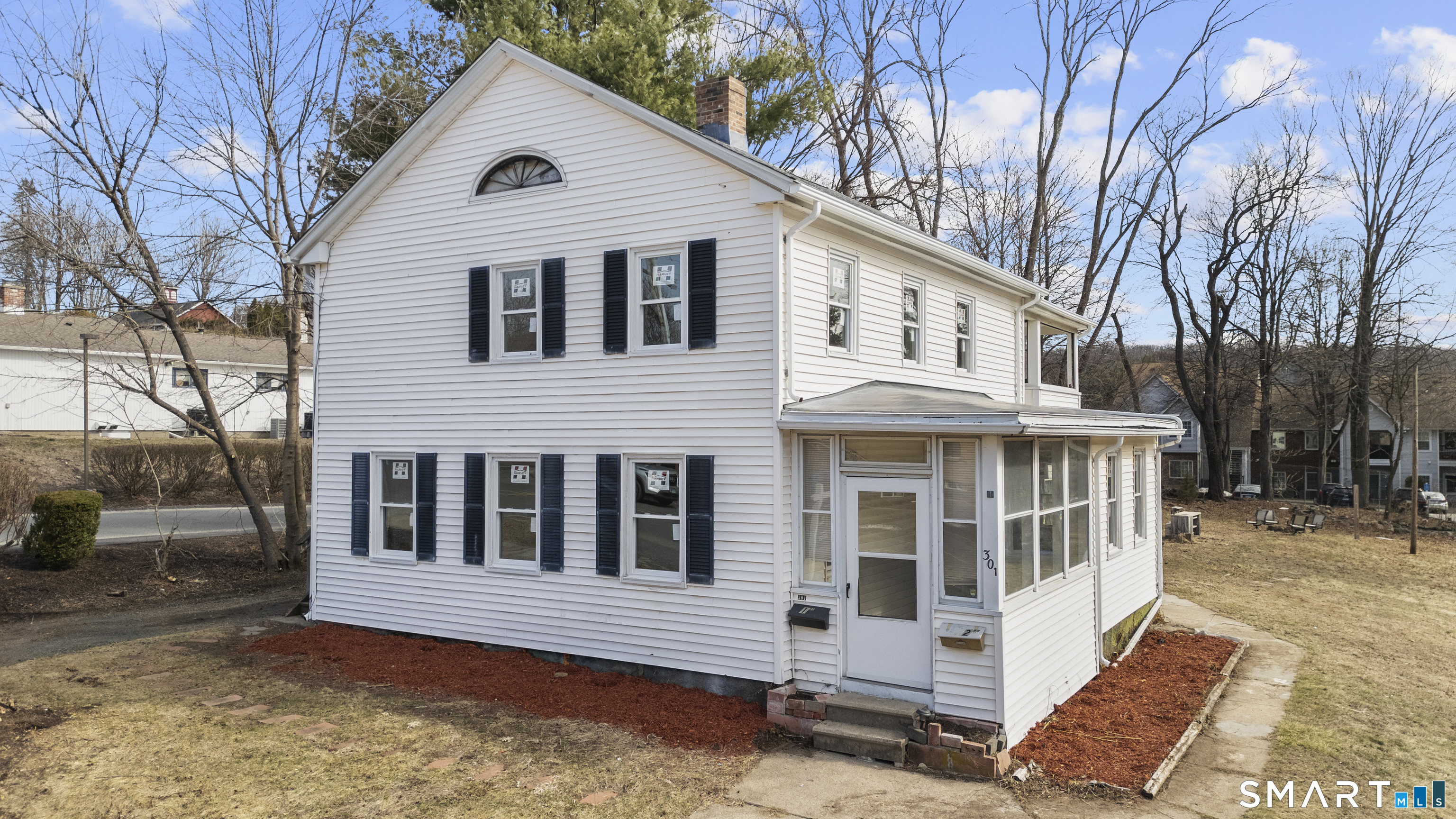 301 Queen Street Bristol, CT 06010 - Photo 3 of 26 a view of a white house with large windows and a small yard