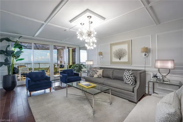 a living room with furniture or chandelier and a wooden floor