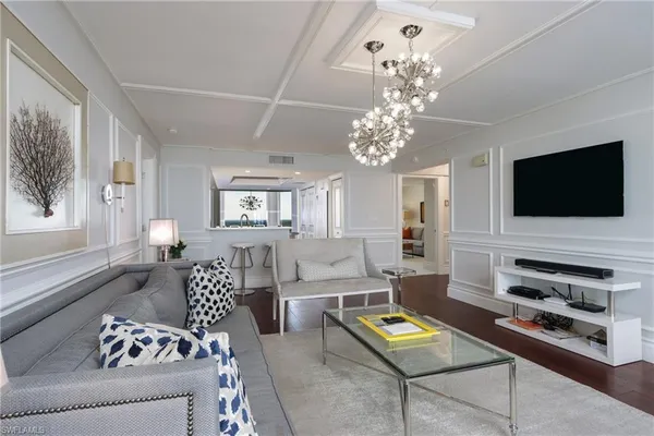 a living room with furniture a flat screen tv and a window