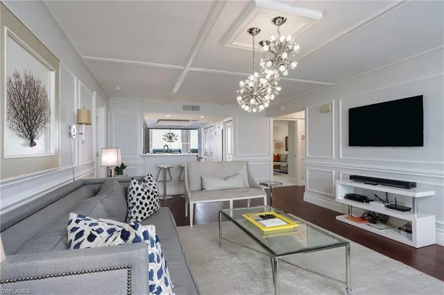 a living room with furniture a flat screen tv and a window