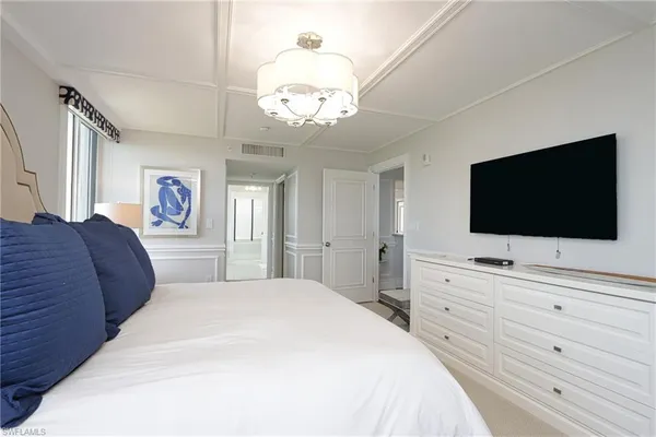 a bedroom with a large bed and a flat screen tv