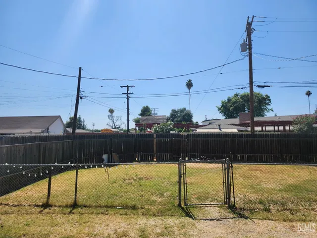 a view of an empty room with wooden floor and windows