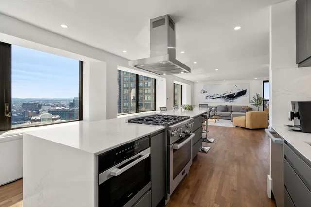 a kitchen with stove and a view of living room