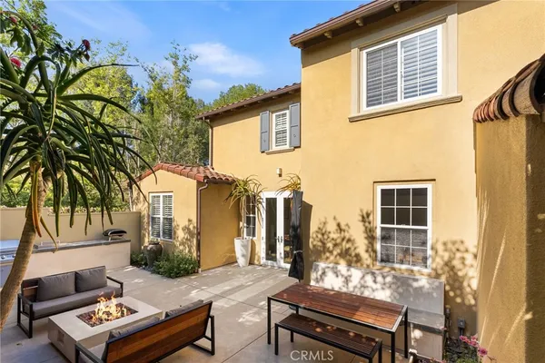a view of a patio with couches table and chairs and potted plants