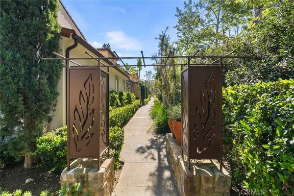 a view of a pathway of a house with wooden fence