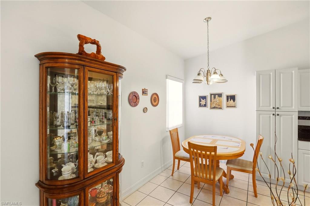 511 Joseph Court, Unit 2 Naples, FL 34104 - Photo 11 of 50 a view of a dining room with furniture and a chandelier