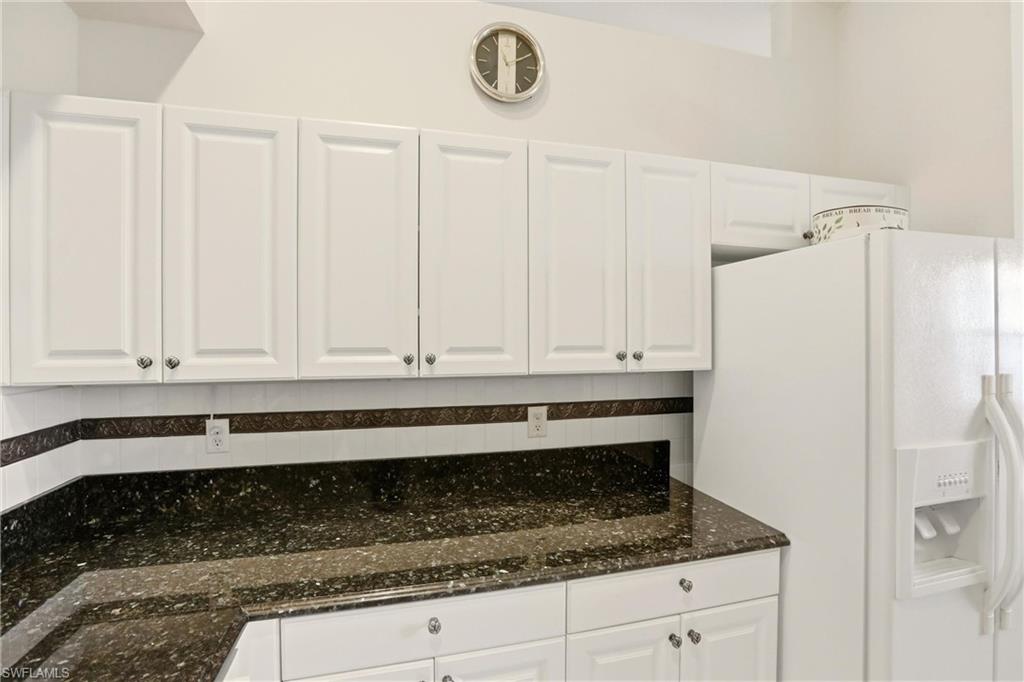 511 Joseph Court, Unit 2 Naples, FL 34104 - Photo 14 of 50 a kitchen with granite countertop white cabinets and a refrigerator