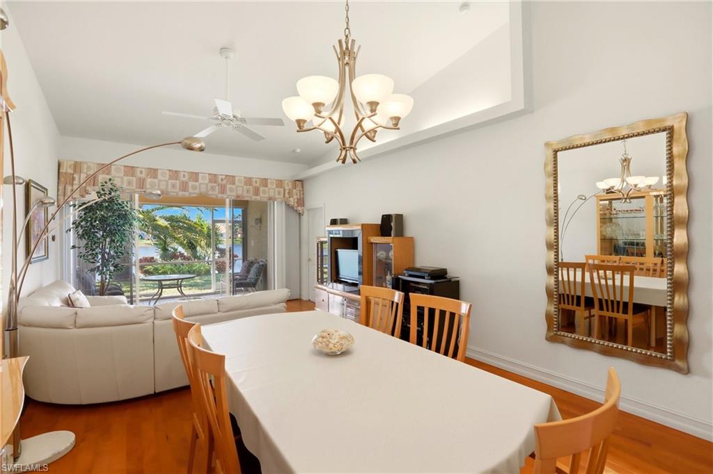 511 Joseph Court, Unit 2 Naples, FL 34104 - Photo 19 of 50 a view of a dining room with furniture a chandelier and wooden floor