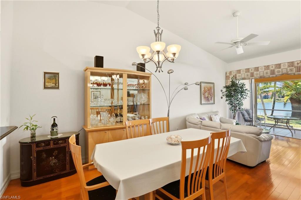 511 Joseph Court, Unit 2 Naples, FL 34104 - Photo 20 of 50 a view of a dining room with furniture wooden floor and chandelier