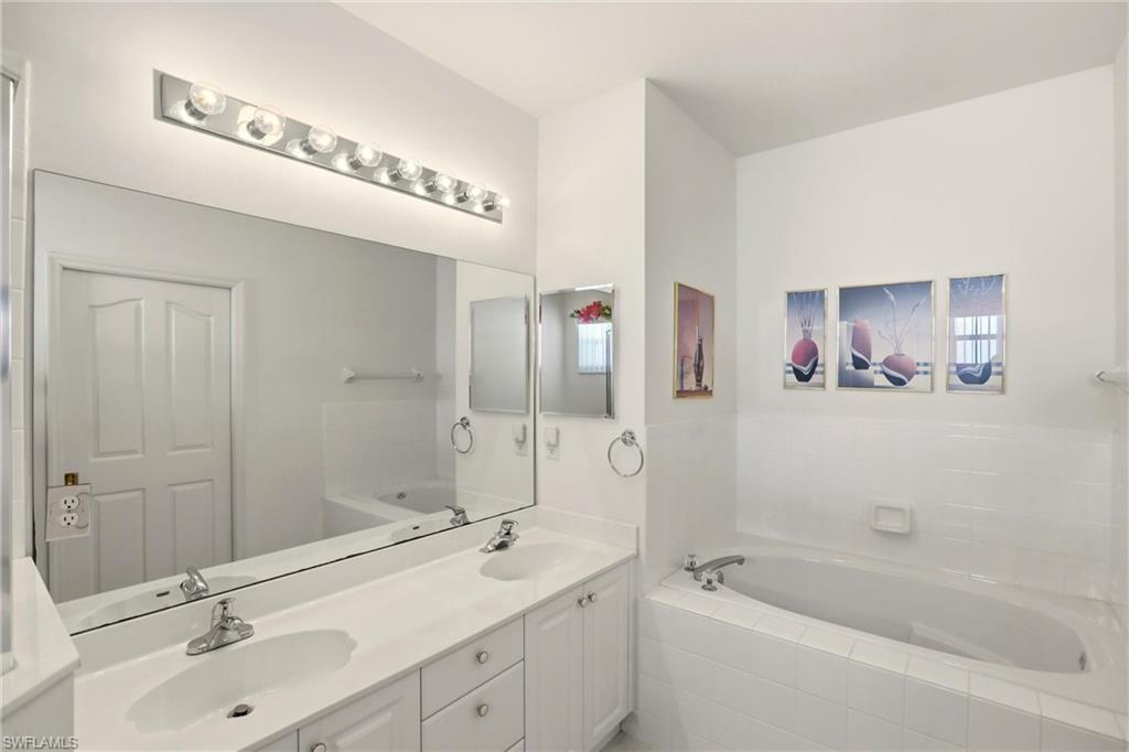 511 Joseph Court, Unit 2 Naples, FL 34104 - Photo 33 of 50 a bathroom with a double vanity sink mirror double and shower
