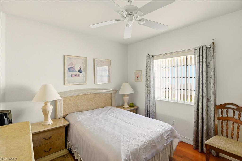 511 Joseph Court, Unit 2 Naples, FL 34104 - Photo 34 of 50 a bedroom with a bed and wooden floor