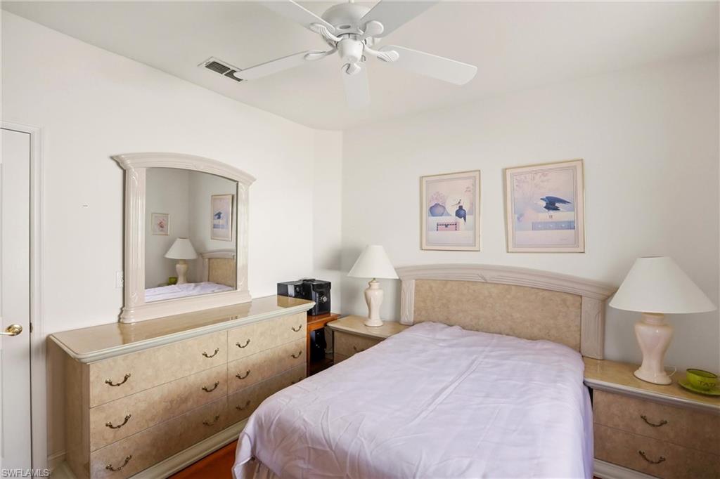 511 Joseph Court, Unit 2 Naples, FL 34104 - Photo 35 of 50 a bedroom with a bed and a chandelier