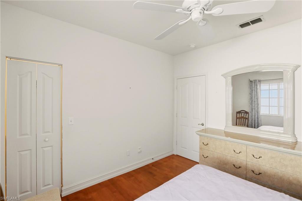 511 Joseph Court, Unit 2 Naples, FL 34104 - Photo 36 of 50 a bedroom with a bed and a mirror