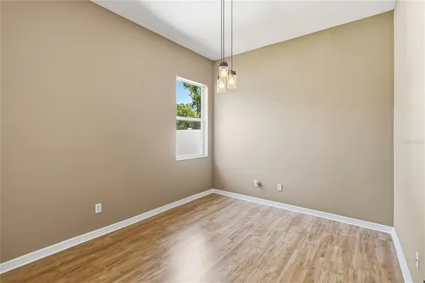 an empty room with a window and wooden floor
