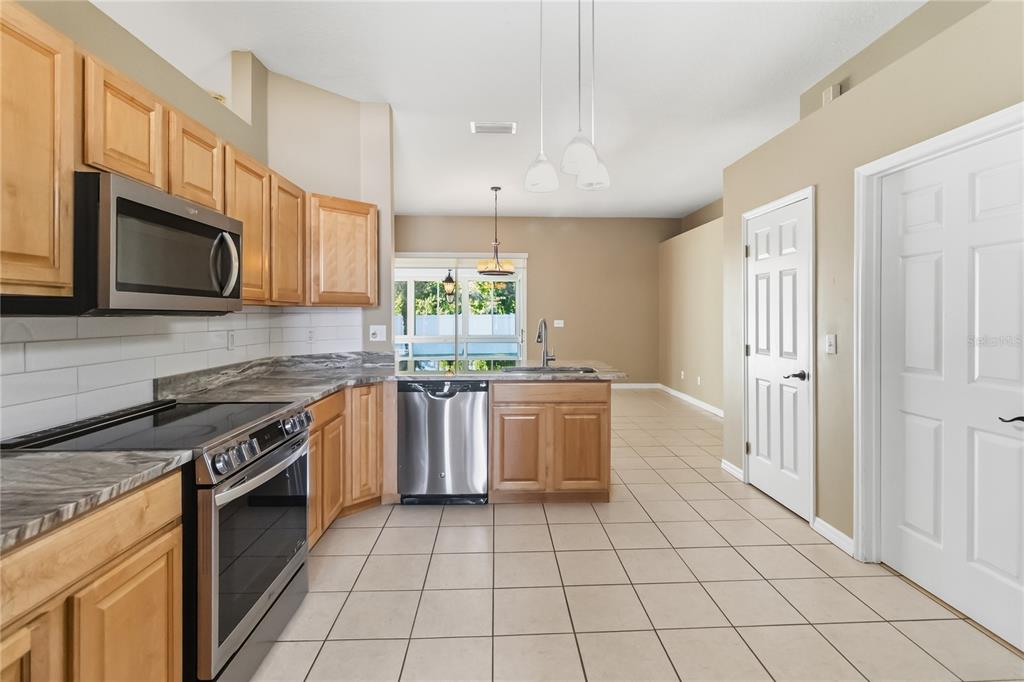 677 Buckhaven Loop Ocoee, FL 34761 - Photo 7 of 41 a kitchen with a stove a sink and a microwave
