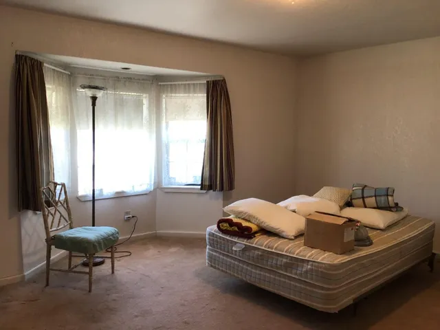 a bed sitting in a bedroom next to a window