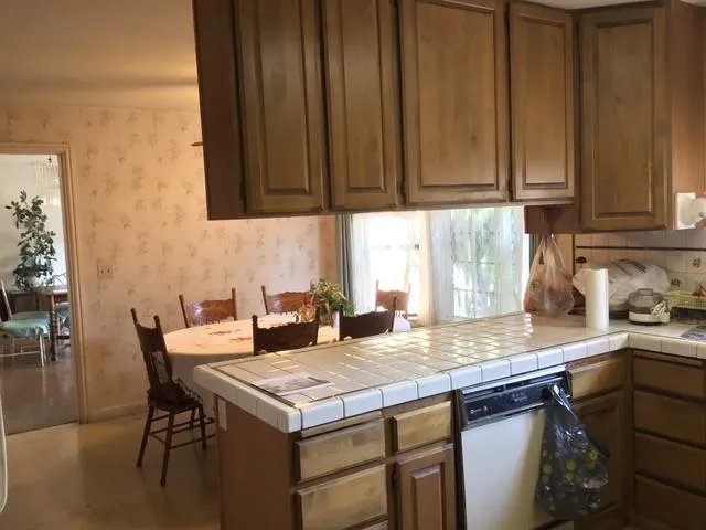 a kitchen with granite countertop a sink a stove and a wooden cabinets