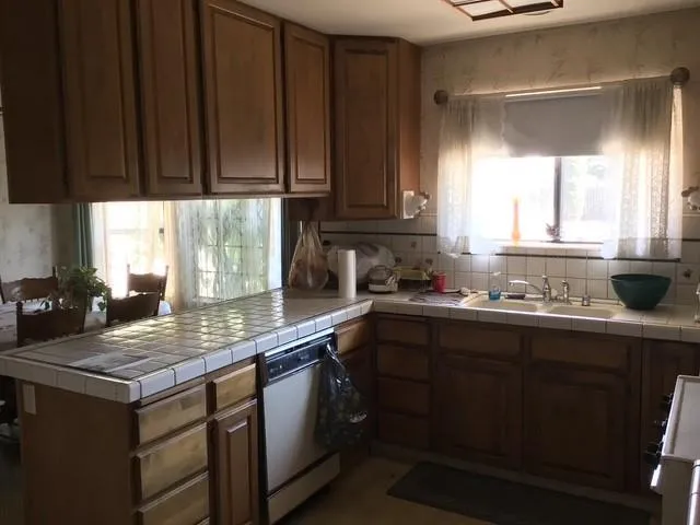 a kitchen with kitchen island granite countertop a sink window and cabinets