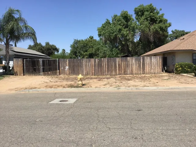 a front view of house with yard and trees around