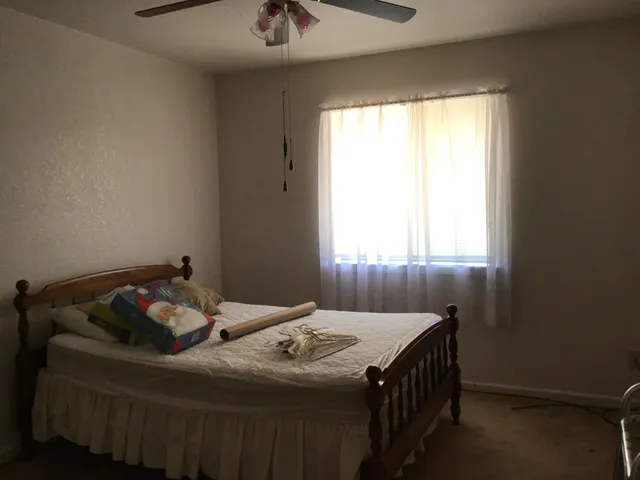 a bedroom with a bed and a window