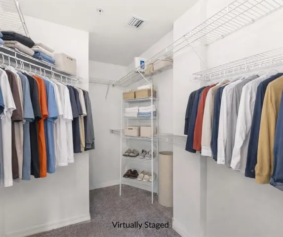 a view of walk in closet with clothes and shoes