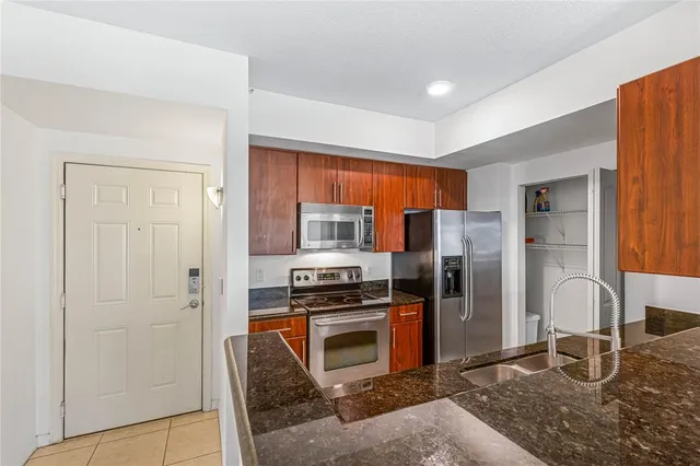 a kitchen with stainless steel appliances granite countertop a refrigerator and a stove top oven
