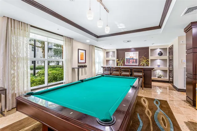 a room with pool table and windows