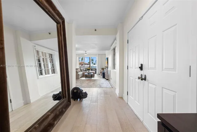 a view of a hallway with wooden floor and a flat screen tv