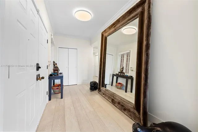 a view of a hallway with wooden floor and a bathroom