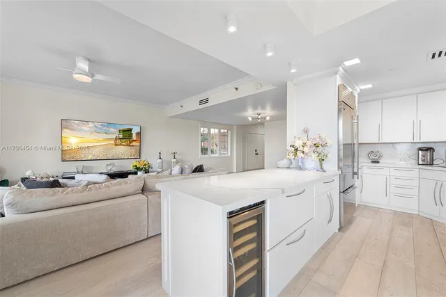 a large white kitchen with a stove a sink a dining table and chairs