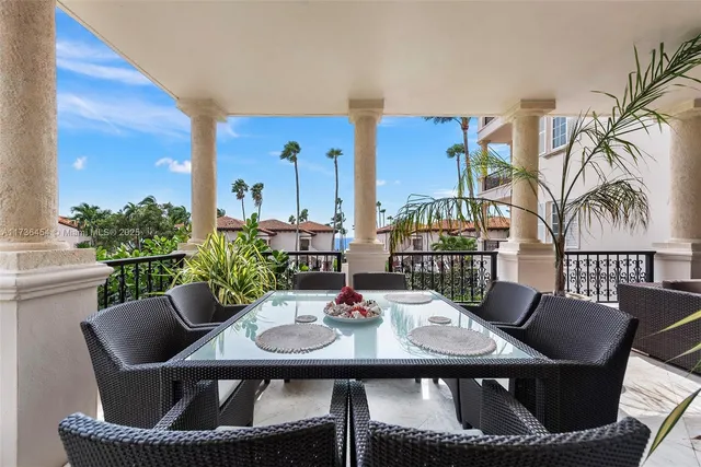 a view of a dining room with furniture one side kitchen view and wooden floor