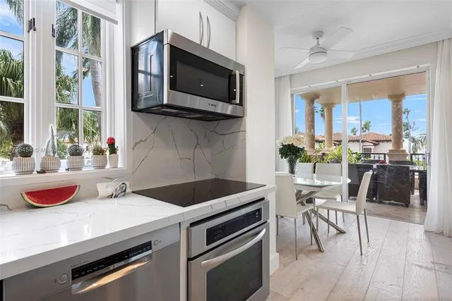 a kitchen with a sink a microwave and chairs
