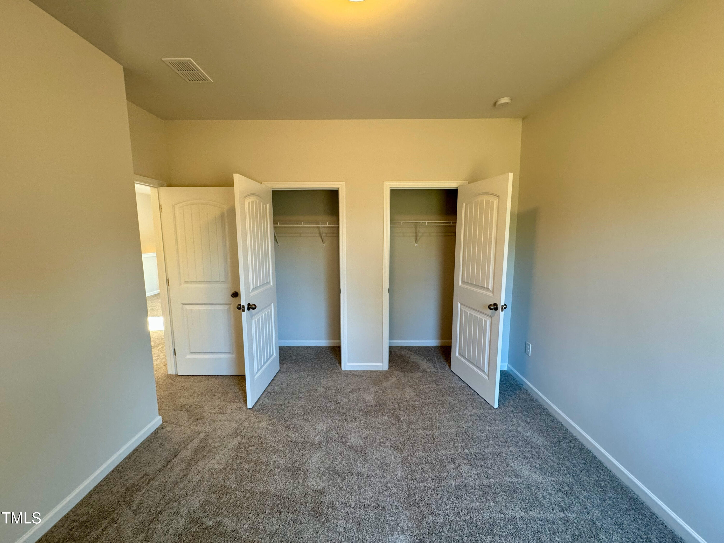 134 Commons Circle, Unit 232 Clayton, NC 27520 - Photo 18 of 37 an empty room with closet and wooden floor